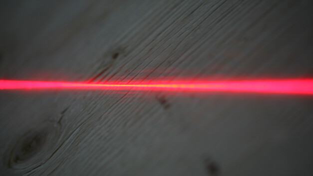 Punainen laserviiva puupinnalla